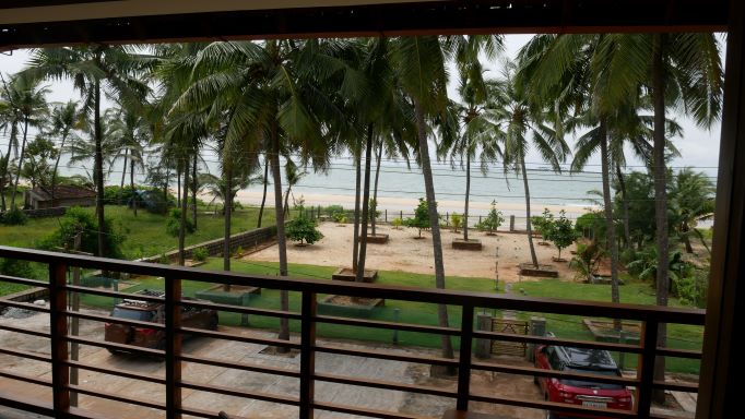 View of garden and parking area with ocean in background